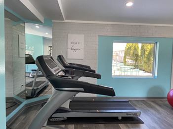a treadmill in front of a window in a gym